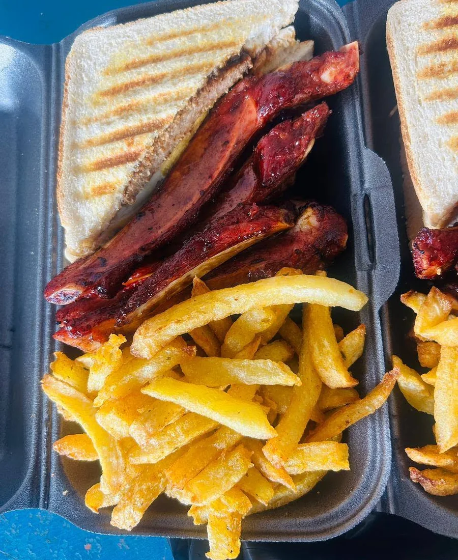 Glazed ribs, chips and toasted sandwiches in a takeaway box